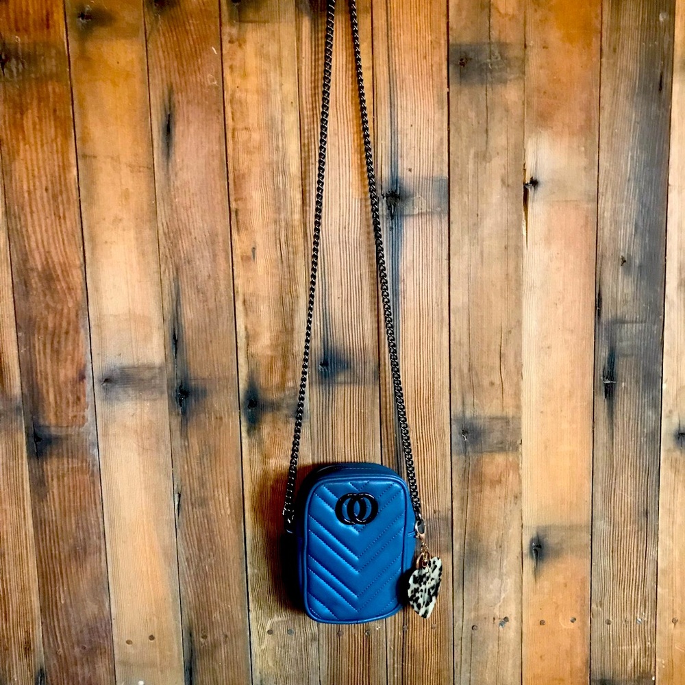 Small gray purse with a crossover chain strap.
